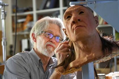 El paleoartista John Gurche le implanta pelo a Shanidar 1, un neandertal masculino, el miércoles 31 de mayo de 2023 en su estudio en Trumansburg, Nueva York. (AP Foto/Heather Ainsworth)