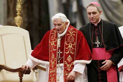 El papa Benedicto XVI, acompañado de su secretario personal, el arzobispo Georg Gaenswein, durante la celebración de una misa por el 900 aniversario de los Caballeros de la Orden de Malta, en la basílica de San Pedro, en el Vaticano, el 9 de febrero de 2013. (AP Foto/Gregorio Borgia, Archivo)