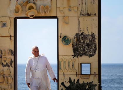 El Papa camina a través de una puerta del monumoneto Puerta de Europa en Lampedusa (Tiziana Fabi/AFP)