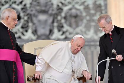El Papa es ayudado a sentarse en una audiencia en el Vaticano. (Photo by Alberto PIZZOLI / AFP)