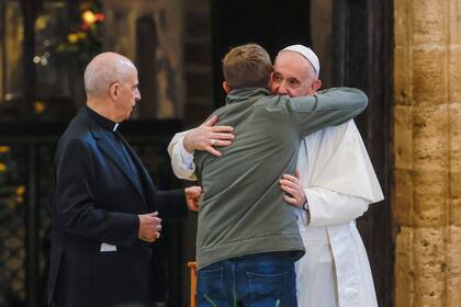 El papa Francisco abraza a un participante de una reunión en la Basílica de Santa Maria de los Ángeles en Asís, Italia, el viernes 12 de noviembre de 2021. (AP Foto/Riccardo De Luca)
