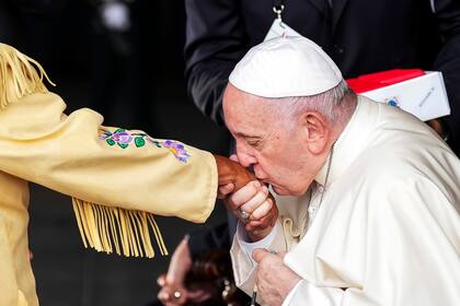 El papa Francisco besa la mano de la venerable indígena Alma Desjarlais, sobreviviente a los malos tratos en internados católicos canadienses, a su llegada el domingo 24 de julio de 2022 a Edmonton, Canadá. (Nathan Denette/The Canadian Press vía AP)