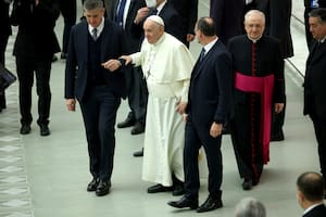 El papa Francisco camina asistido por colaboradores porque sufre dolor de rodilla