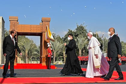 El Papa Francisco camina junto al presidente iraquí, Barham Saleh, durante una ceremonia de bienvenida en el palacio presidencial en Bagdad