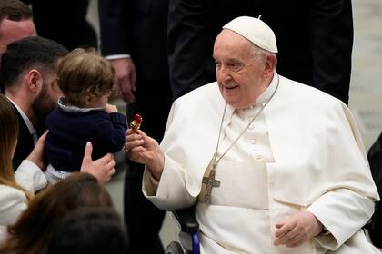 El papa Francisco da un dulce a un bebé al final de su audiencia semanal en el Vaticano, el miércoles 28 de febrero de 2024. (AP Foto/Andrew Medichini)