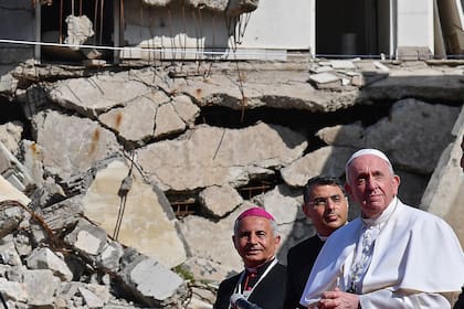 El Papa Francisco (derecha), acompañado por el arzobispo católico caldeo de Mosul Najib Michaeel Moussa (3rd-R), mira una plaza cerca de las ruinas de la Iglesia católica siríaca de la Inmaculada Concepción (al-Tahira-l-Kubra ), en la ciudad vieja del norte de Mosul en Irak el 7 de marzo de 2021. (Foto de Vincenzo PINTO / AFP)