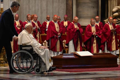 El papa Francisco es empujado en una silla de ruedas por el ataúd del cardenal australiano George Pell, durante una misa fúnebre en la basílica de San Pedro en el Vaticano