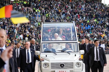 El papa Francisco es saludado por fieles a su llegada para presidir una misa en el estadio Rey Balduino en Bruselas, el domingo 29 de septiembre de 2024. (AP foto/Andrew Medichini)