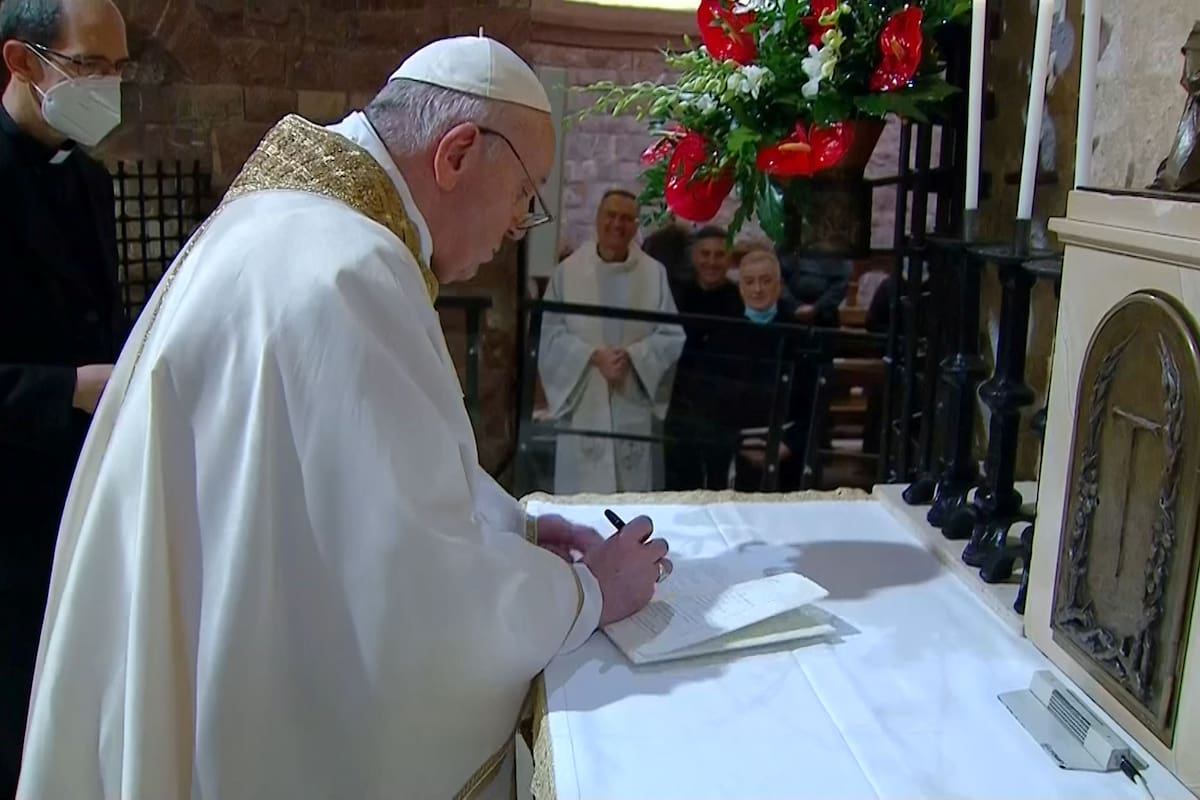 El Papa Francisco firma su última encíclica, titulada "Fratelli Tutti" (Hermanos todos), en la cripta donde está enterrado San Francisco de Asís en Asís, Italia, el 3 de octubre de 2020 en esta captura de pantalla obtenida de un video.