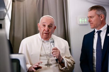 El papa Francisco junto al portavoz del Vaticano, Matteo Bruni, a bordo del avión que el 31 de enero de 2023 lo llevará de Roma a Kinshasa para su visita a la República Democrática del Congo y Sudán del Sur.