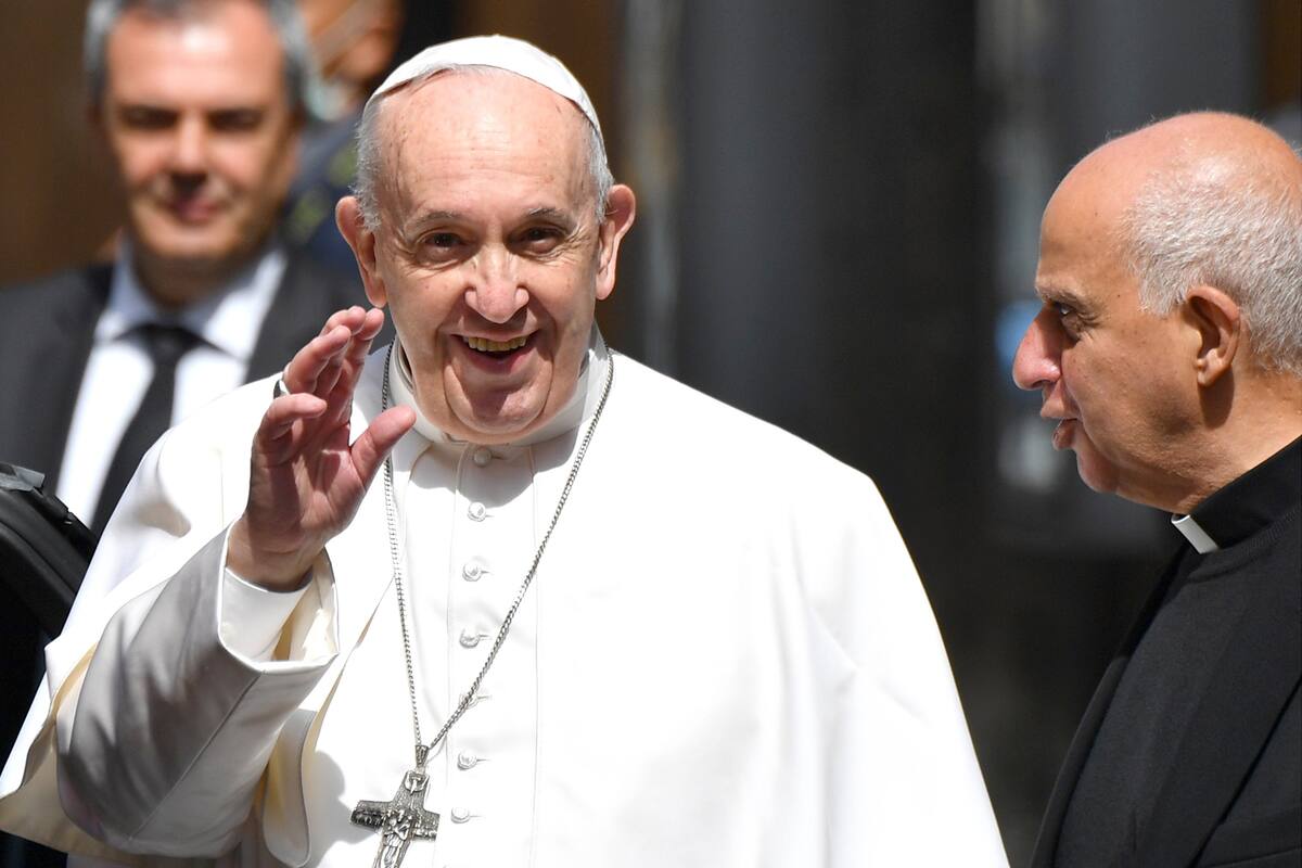 El Papa Francisco saluda a los medios de comunicación al lado del Obispo Rino Fisichella cuando sale de la iglesia de Santo Spirito en Sassia en Roma después de celebrar la misa de la Fiesta de la Divina Misericordia a puertas cerradas el 19 de abril de 2020 durante el cierre del país destinado a de
