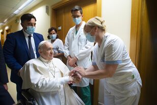El papa Francisco saluda a personal del hospital, sentado en una silla de ruedas dentro de la Policlínica Agostino Gemelli