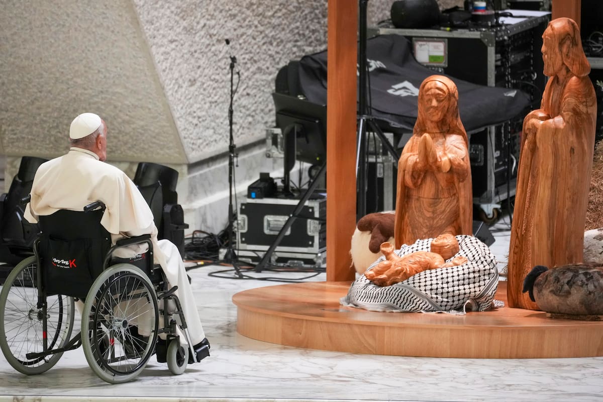 El Papa reza frente a un niño Jesús acostado sobre un pañuelo palestino