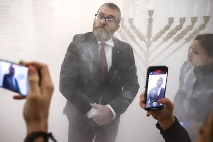 El parlamentario polaco Grzegorz Braun tras apagar las velas de Hanukkah con un matafuego
