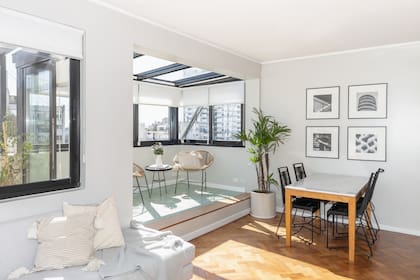 El parquet original, que estaba bajo la alfombra, se recuperó con pulido e hidrolaqueado. Mesa de madera y mármol (Wa Aquitectura) y sillas de hierro y PVC.