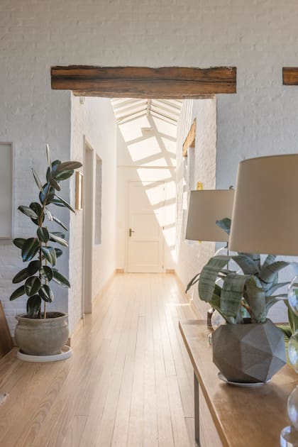 El pasillo, con techo vidriado, conecta el living, la cocina y el playroom.