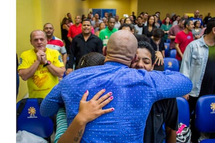 El Pastor Fabio de Souza abraza a la fiel Katia Maria Soares a su compañera Carolina y a su hijo durante el servicio dominical en la Iglesia Cristiana Contemporanea, la primera en el país en aceptar miembros de la comunidad LGBT, en Madureira, en Río de Janeiro