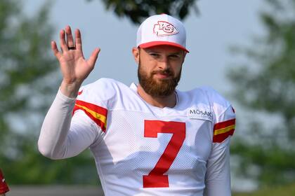 El pateador de los Kansas City Chiefs, Harrison Butker, saluda a los fanáticos mientras camina hacia el campo al comienzo de un campamento de entrenamiento de fútbol americano de la NFL, el sábado 27 de julio de 2024, en St. Joseph, Misuri. (AP Foto/Reed Hoffmann)