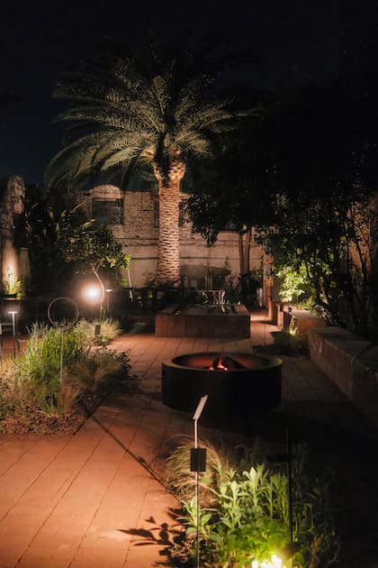 El patio con una gran palmera y fogonero es un oasis en la ciudad