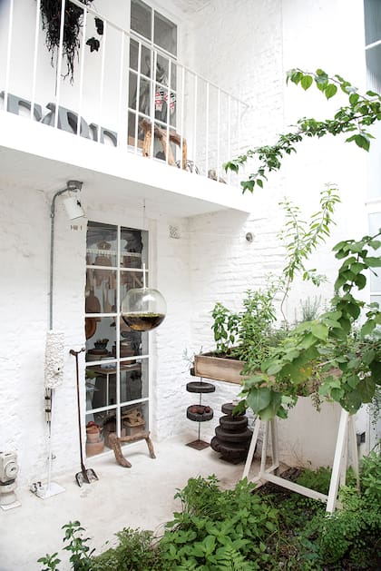El patio de la cocina aloja la huerta elevada sobre un caballete. En el suelo crecen plantitas espontáneamente. Además, detalles realizados por Julio, como el jardín de agua colgante