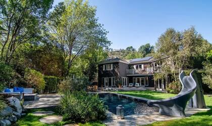 El patio trasero de la mansión cuenta con una piscina con tobogán (MLS.com)