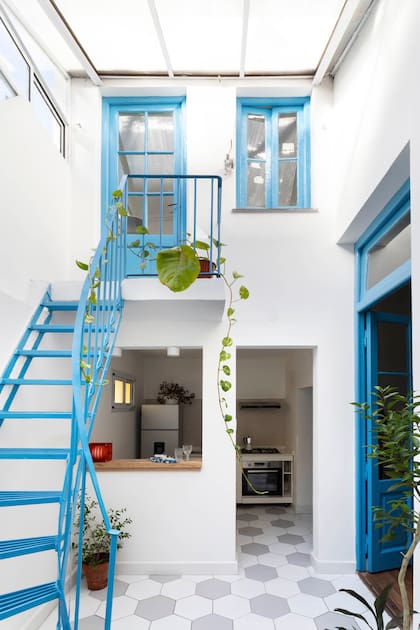 El patrón de hexágonos blancos y grises quita rigidez y unifica patio y cocina para que se perciban más amplios.