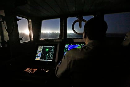 Los barcos, en su mayoría chinos, despliegan grandes brazos metálicos con potentes luces que atraen a los calamares, que son atrapados con las poteras