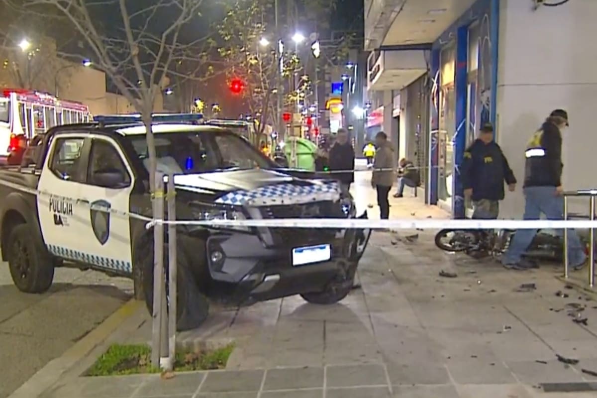 El patrullero dañado y a moto tumbada sobre la vereda, luego del fuerte impacto