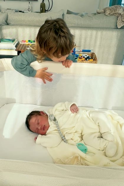 El pequeño Cyan, de dos años, observa con curiosidad a su nuevo hermanito