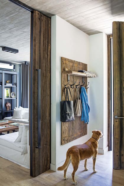 El perchero y la puerta de entrada están hechos con madera de lapacho recuperada, diseñado por Estudio Pirca.
