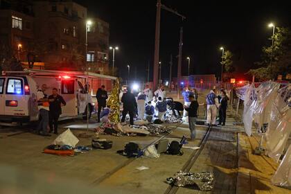 El personal de emergencia israelí ayuda a las víctimas en el sitio de un ataque denunciado en un barrio de colonos en Jerusalén Este