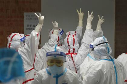 El personal médico se animó antes de ingresar a una sala de UCI para pacientes con coronavirus en Wuhan
