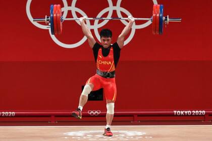 El pesista chino Li Fabin sostiene 166 kilos con una sola pierna.