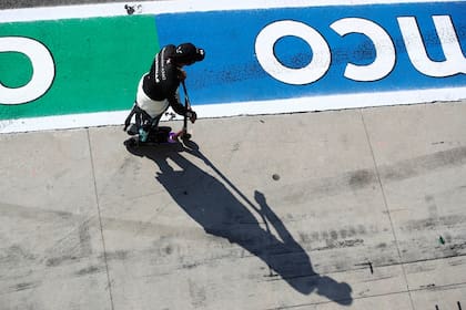 El piloto de Mercedes Lewis Hamilton se dirige en monopatín a revisar el fallo que lo obligó a retrasarse diez segundos