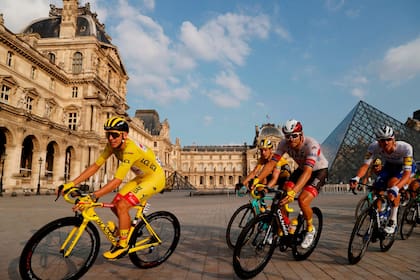 Frente a la pirámide del Louvre el pelotón acompaña al campeón Pogacar