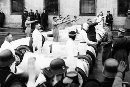 El piloto Rudolf Caracciolo saluda a Adolf Hitler; el Führer financió un programa para que Mercedes y Auto Unión representaran la superioridad de la industria automotriz alemana en los Grand Prix