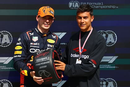 El piloto neerlandés Max Verstappen y el futbolista Paulo Dybala en Silverstone, en una ceremonia habitual de la Fórmula 1: el poleman firma un neumático para una figura reconocida.
