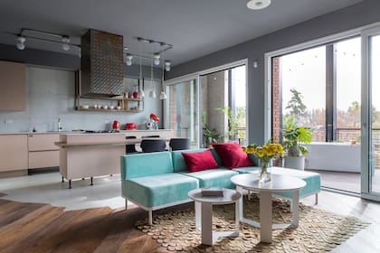 El piso es característico de esta arquitecta, con materiales que no se encuentran en una línea recta, en este caso, madera (Patagonia Flooring) y porcelanato ‘Filomena claro’ (Cerámicas San Lorenzo). Campana diseñada por Soqueff y realizada por Herrería Bruto. Anafe de Longvie. Sofá (Grupo a2).