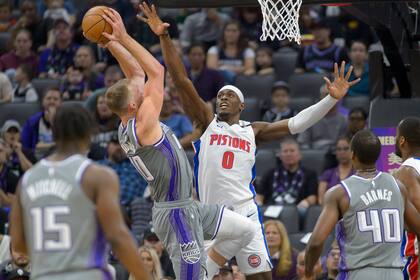 El pívot de los Pistons de Detroit Jalen Duren (0) intenta bloquear un tiro del alero Domantas Sabonis (10), de los Kings de Sacramento, durante el primer cuarto del juego de baloncesto de la NBA, en Sacramento, Calif., el domingo 20 de noviembre de 2022. (AP Foto/Randall Benton)