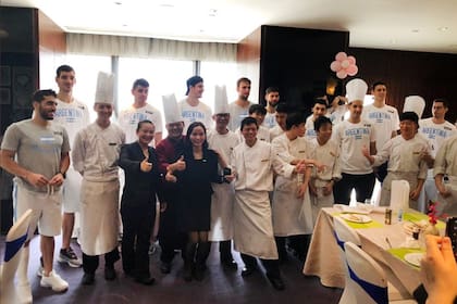 El plantel argentino, en China, junto a los cocineros del hotel donde se alojan.