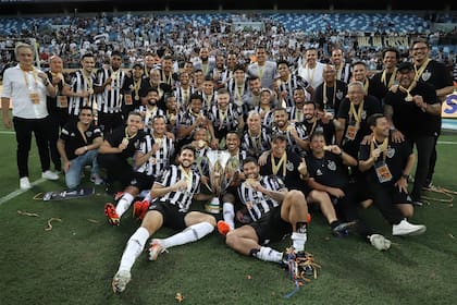 El plantel y cuerpo técnico de Atlético Mineiro posa con la Supercopa do Brasil después de vencer a Flamengo por penales.