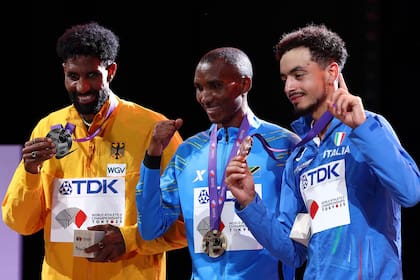 El podio: Alphonce Simbu con el oro, a su derecha el eritreo Amanal Petros, que representa a Alemania, y a su izquierda el italiano Iliass Aouani, que se quedó con el bronce