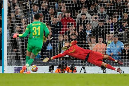 El portero del Real Madrid Andriy Lunin se lanza para intentar detener el gol de Ederson del Manchester City en el duelo de vuelta de los cuartos de final de la Liga de Campeones el miércoles 17 de abril del 2024. (AP Foto/Dave Shopland)
