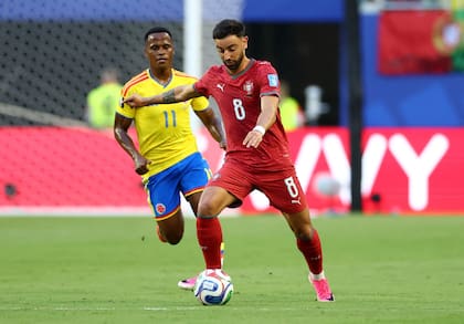 El portugués Bruno Fernandes lleva la pelota ante la marca distante del colombiano Jhon Arias