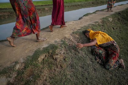 Una mujer agotada, que huye de la violencia en Myanmar, pide ayuda a otros que cruzan a Palang Khali, cerca de Coxs Bazar, Bangladesh (2 de noviembre de 2017)