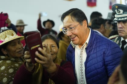 El presidente boliviano, Luis Arce, se toma una selfie con un partidario después de asistir a una asamblea de trabajadores agrícolas de la Confederación de Pueblos Interculturales de Bolivia, en La Paz, Bolivia, el martes 3 de octubre. (AP/Juan Karita)