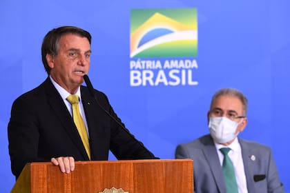 El presidente brasileño, Jair Bolsonaro, habla junto al ministro de Salud, Marcelo Queiroga, durante la ceremonia de inauguración de un nuevo registro de pescadores profesionales, en el Palacio Planalto de Brasilia