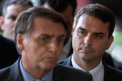 El presidente brasileño Jair Bolsonaro junto a su hijo, el senador Flavio, que hoy fue imputado por corrupción