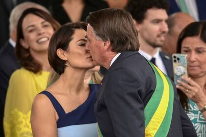 El presidente brasileño Jair Bolsonaro y la primera dama Michelle Bolsonaro se besan durante un desfile militar para conmemorar el 200 aniversario de la independencia de Brasil en Brasilia, el 7 de septiembre de 2022.