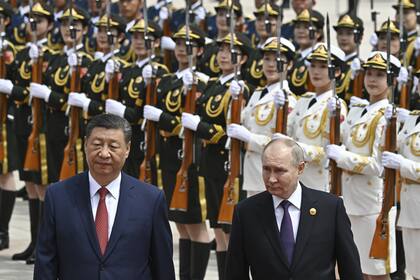 El presidente chino Xi Jinping (izquierda) y el presidente ruso Vladimir Putin pasan revista a la guardia de honor durante una ceremonia oficial de bienvenida en Pekín